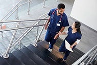 Does Your Innovation Team Include Nurses photo of two nurses walking up stares discussion a patient