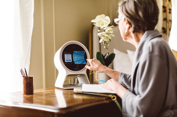 Innovative Devices Engage Patients in Their Health — at Home and on the Run. A woman accesses a standalone desktop device with a touch screen to access medical care.