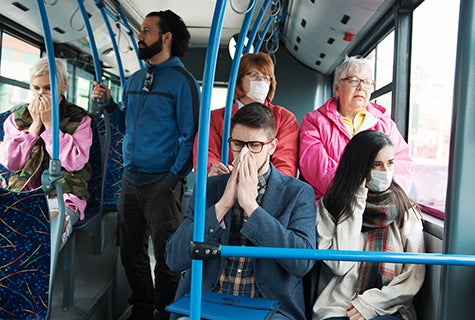 stock photo of crowded bus with some sick riders and other riders wearing masks