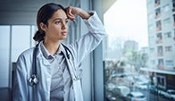 minority female doctor stares out of window