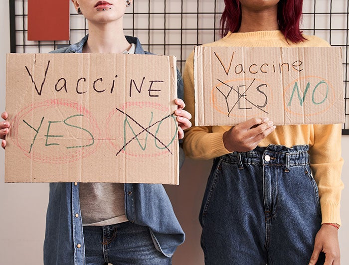 stock photo of people holding signs that say Vaccine? Yes or No