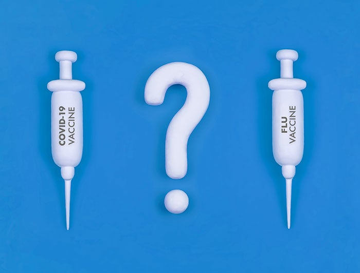 Two syringes flanking a question mark
