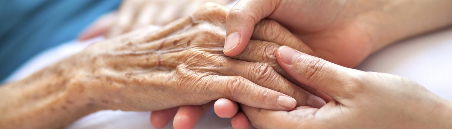 Hands of young person is holding hand of an elderly person 