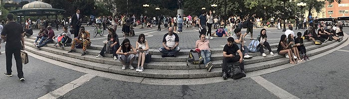 wide view of people sitting on stairs in a park
