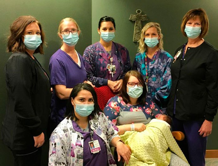 St. Anthony staff take photo with patient and baby