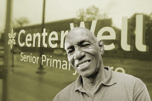 Humana Again Expands Its Profile in Primary Care for Seniors. A senior black patient stands in front of a CenterWell Senior Primary Care sign.