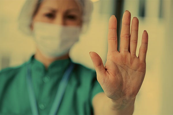 nurse with her hand up saying stop
