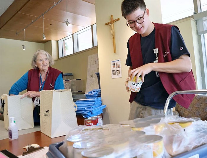 Volunteers pack grocery bags for new mothers