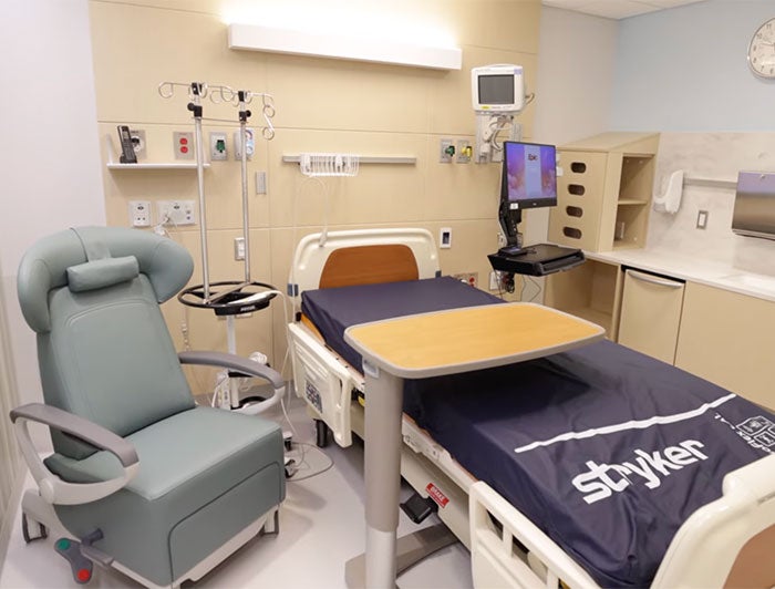 Short stay room includes a patient bed and a visitor chair