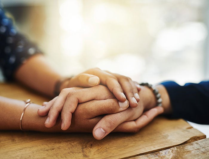 stock photo: close shot of hands held across a wooden table