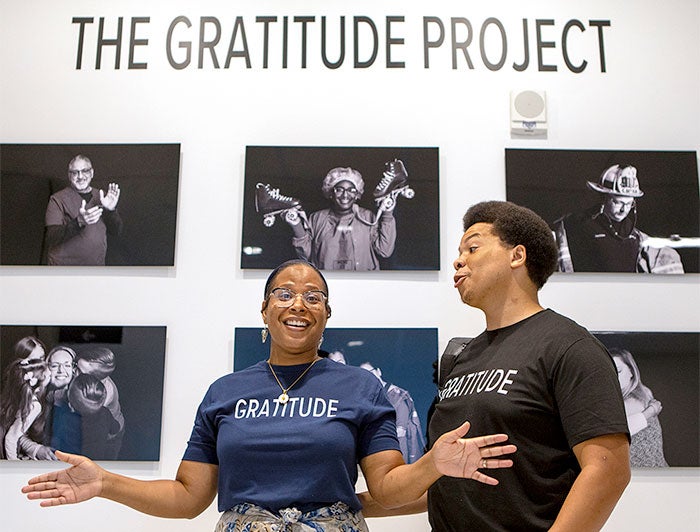 Penn State Lancaster Medical Center. The gratitude project producers stand in front of wall of photos