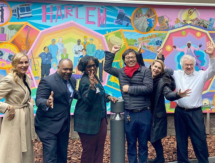 NYC Health + Hospitals. artist Ji Yong Kim and others in front of the mural Chromatic Symphony of Greater Harlem