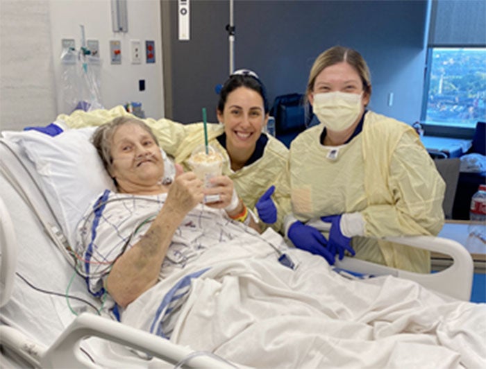University of Pennsylvania Hospital. PennHOPES patient sits smiling in hospital bed holding Starbucks Frappucino