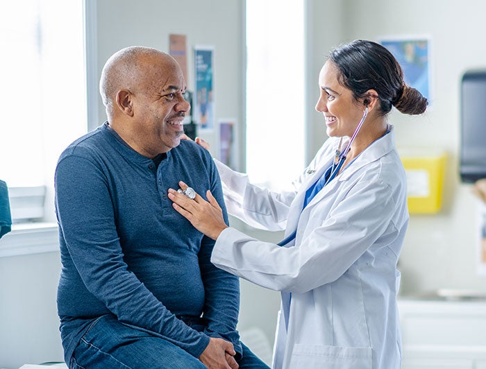 MUSC. A female doctor listens to an older male patients heart.