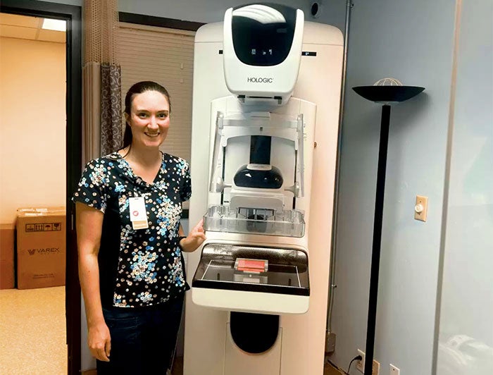 Petersburg Medical Center. Female clinician stands with new 3d mammography device