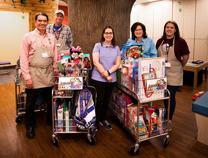 University of Kentucky Albert B. Chadler Hospital. Hospital staff and volunteers gather around the Joy Cart