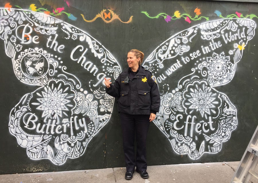 police officer in front of chalk drawing of butterfly