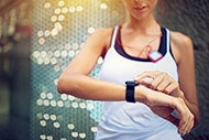 Consumers Ready to Trade Health Device Data for Rewards: Woman exercises checks her wearable health device on her wrist