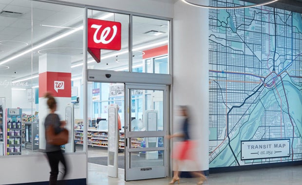 Walgreens Begins Executing New Health Care Strategy. The outside of a Walgreens store with a transit map on the wall next to the door.