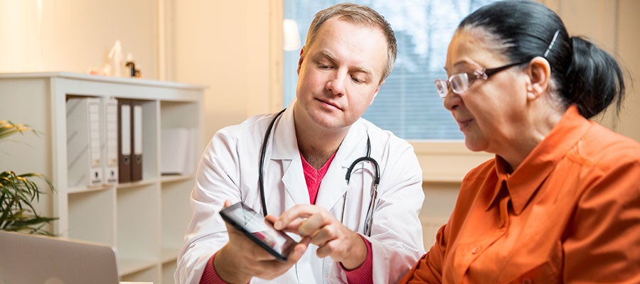 AHA Patient Safety Initiative. A doctor shares health information on a tablet computer with a patient.