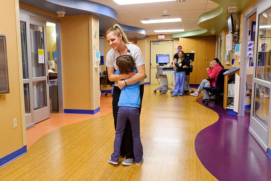 A pediatric patient hugging a nurse