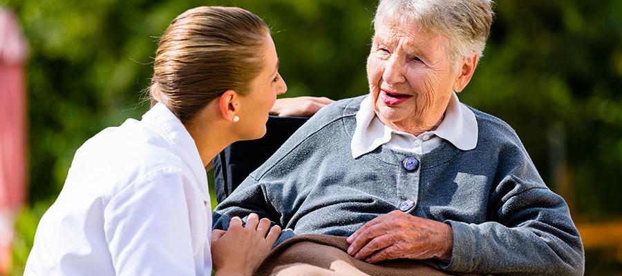 nurse helping senior in wheelchair