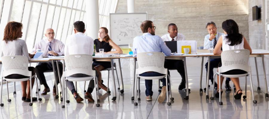 Doctors sitting in chairs at a table.