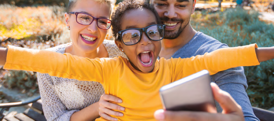 Mother, father, and child taking a self and enjoying good health