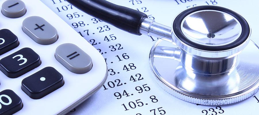 calculator and stethoscope over spreadsheet