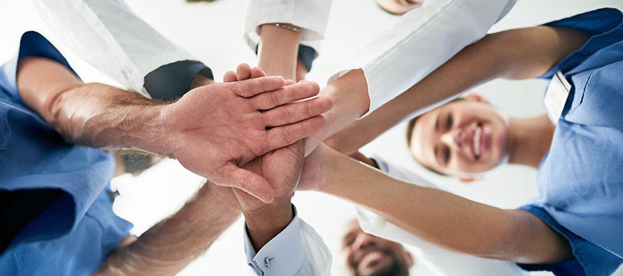 physicians huddling with hands in circle