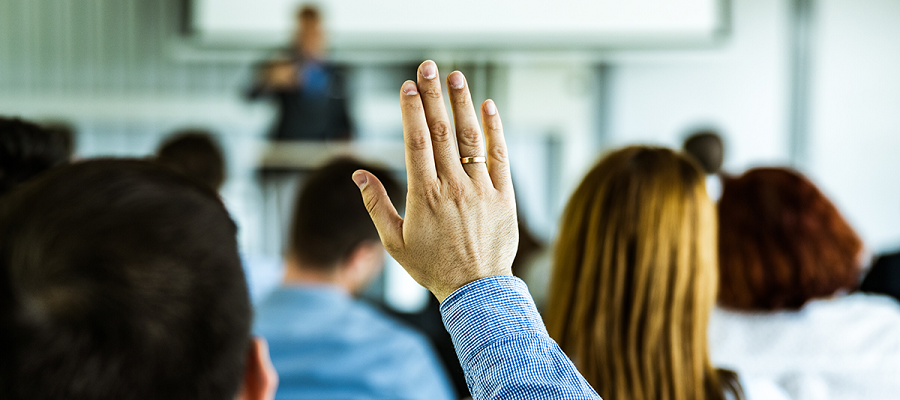 Health Care Risk Management Week celebrates risk management professionals. A professional risk management man raises his right hand during a training sessions.