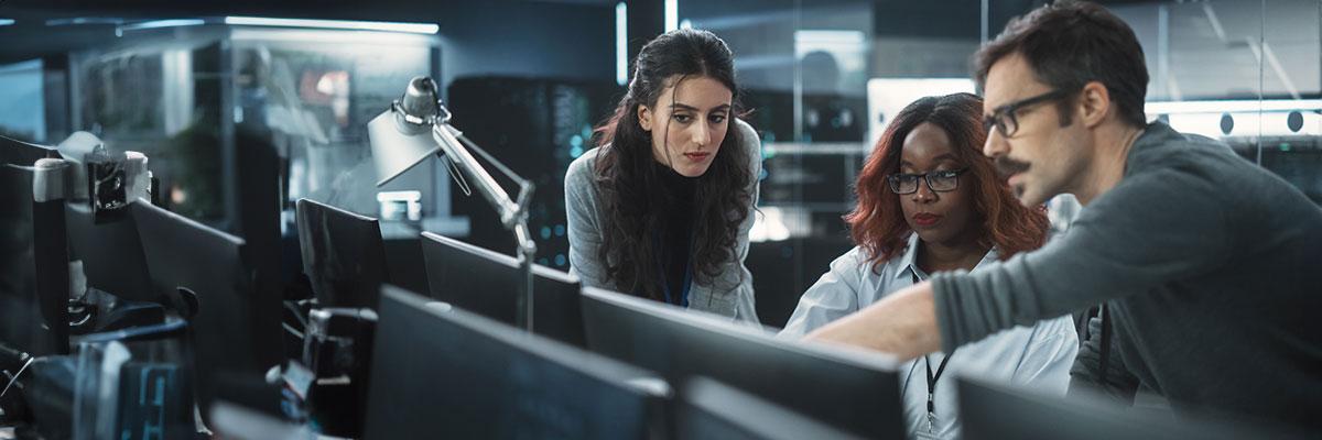 Tech workers gather around a computer screen