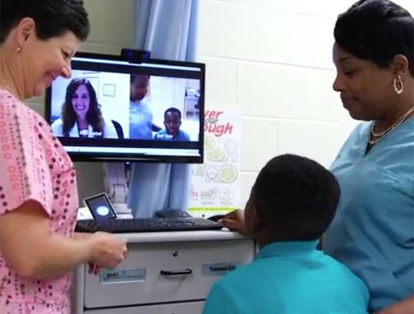 A nurse assists a boy and his mother who are talking with a doctor via a telehealth system at MUSC in Charleston, South Carolina.