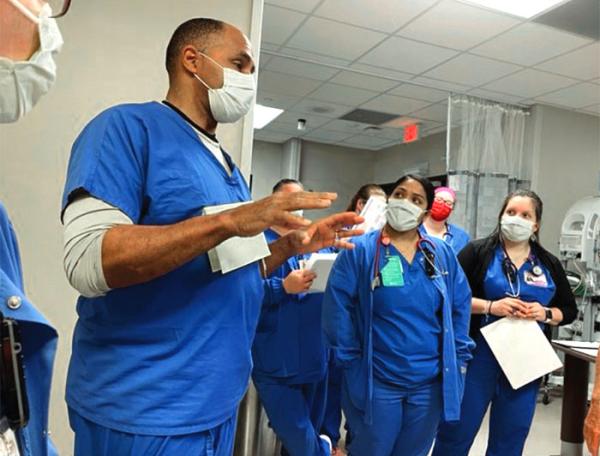 Children's Hospital San Antonio clinicians stand talking during rounds or other team meeting