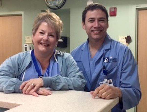 Norwegian Hospital clinicians stand at desk smiling