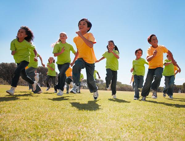 stock photo of diverse children running in a sunny field