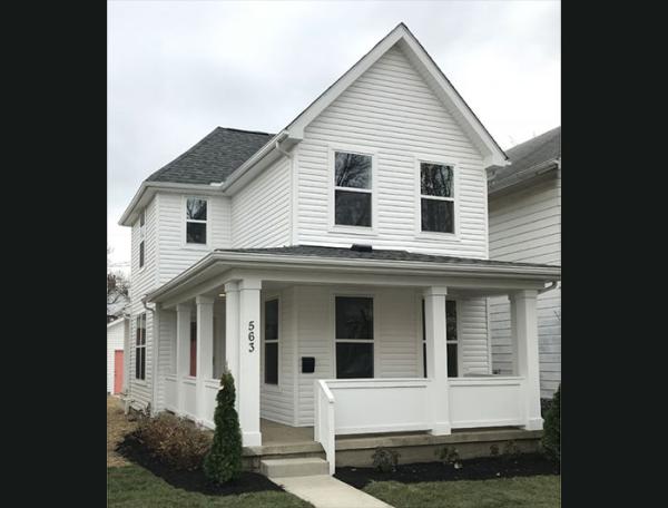 A white two-storey house with wraparound porch