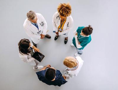 stock image - aerial shot of a care team in conversational huddle